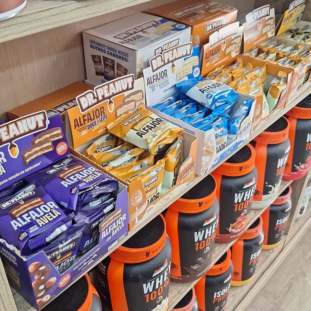 Prateleira com Dr. Peanut alfajores proteicos e New Millen Whey na Fórmula Store